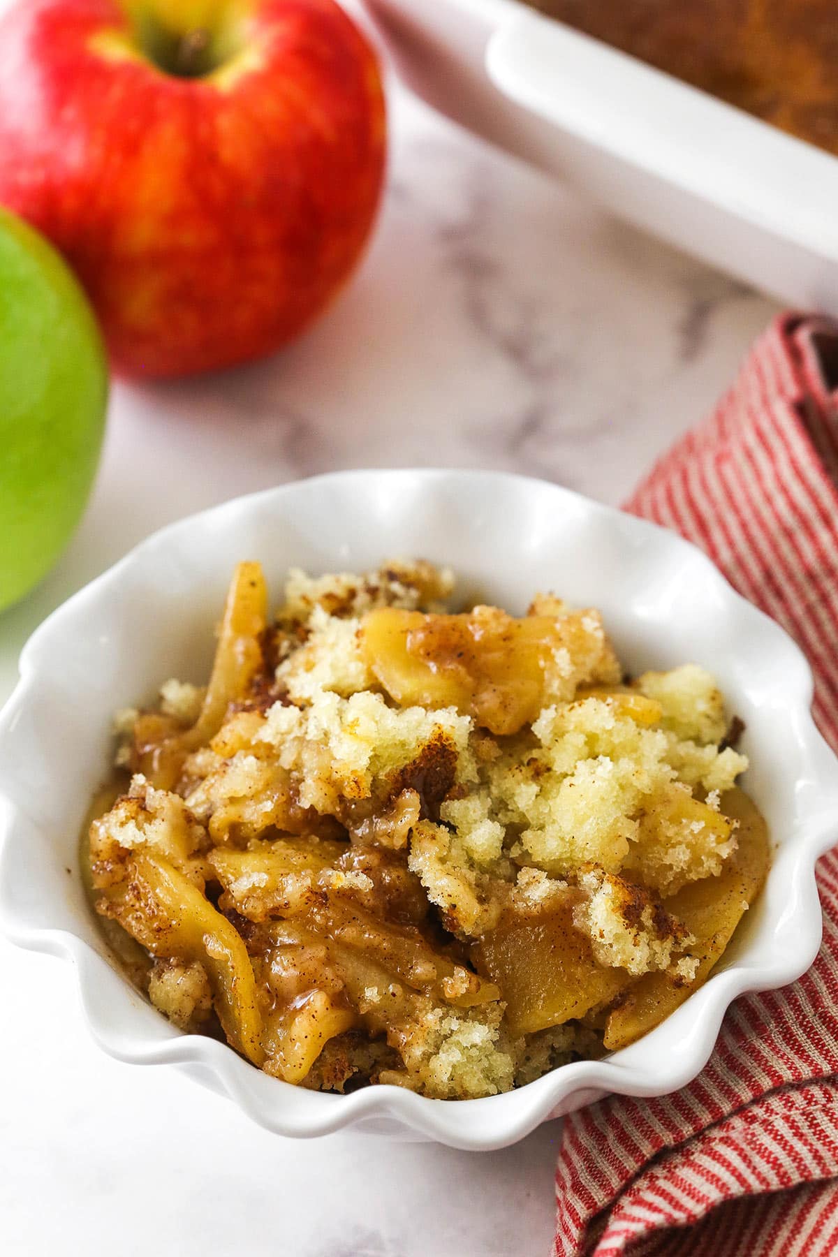 A serving of homemade apple cobbler in a bowl on a marble countertop