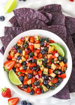overhead image of berry fruit salsa in white bowl with blue tortilla chips