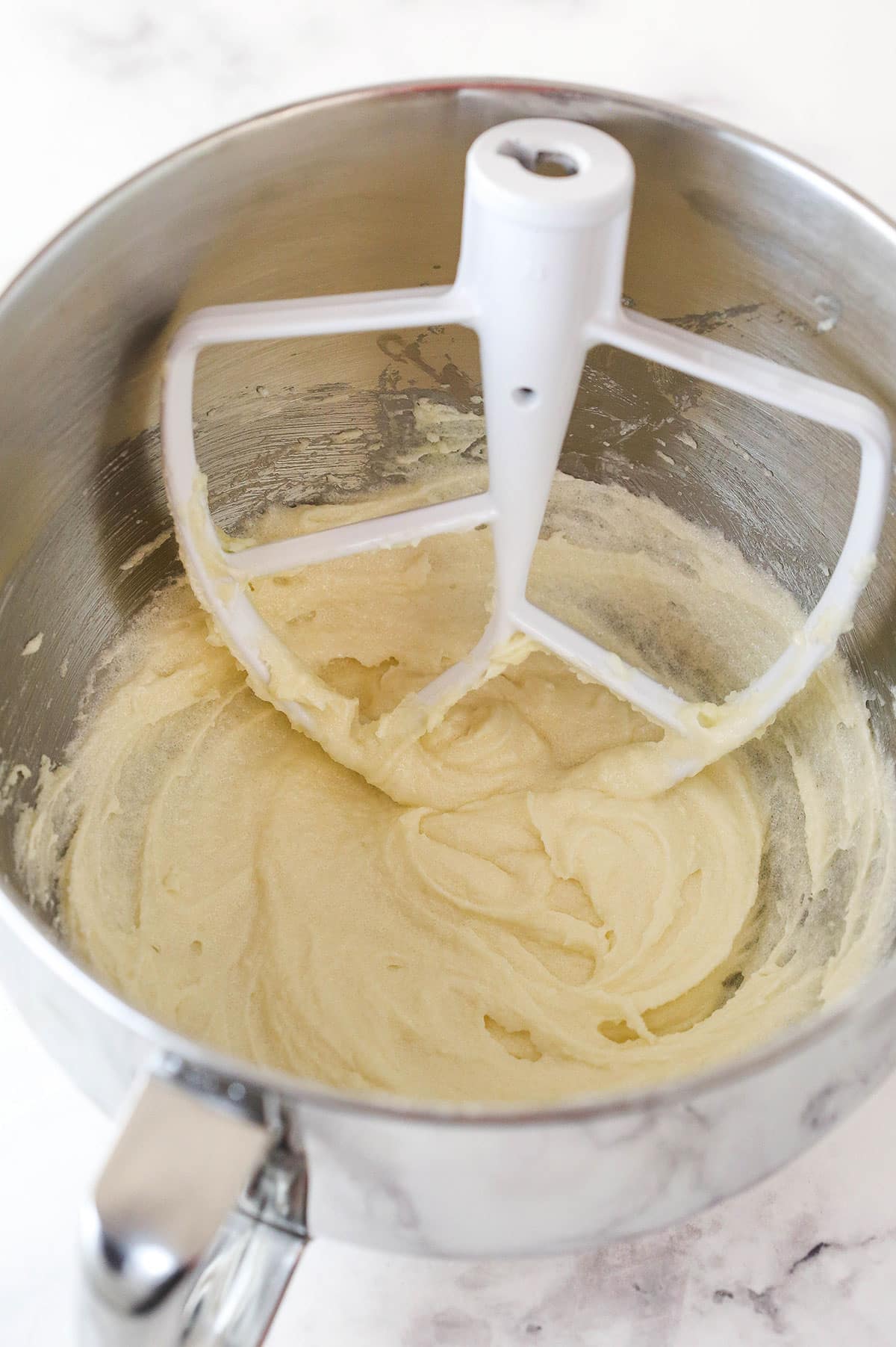 Overhead view of butter, sugar, oil and vanilla extract combined in a large mixing bowl