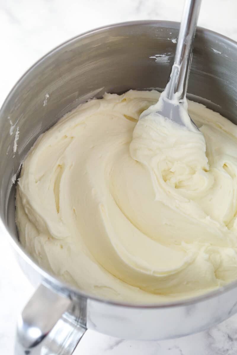 Stirring vanilla buttercream in a mixing bowl.