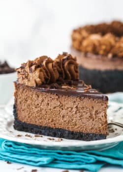 A slice of chocolate cheesecake with Oreo crust on a plate.