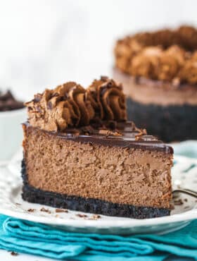 A slice of chocolate cheesecake with Oreo crust on a plate.
