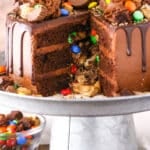Side view of a Chocolate Piñata Cake with a slice removed on a gray cake stand
