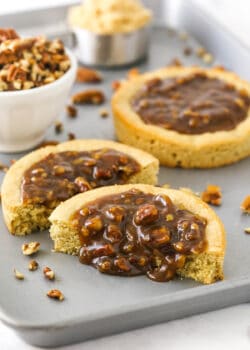 A pecan pie cookie cut in half with the homemade filling oozing out