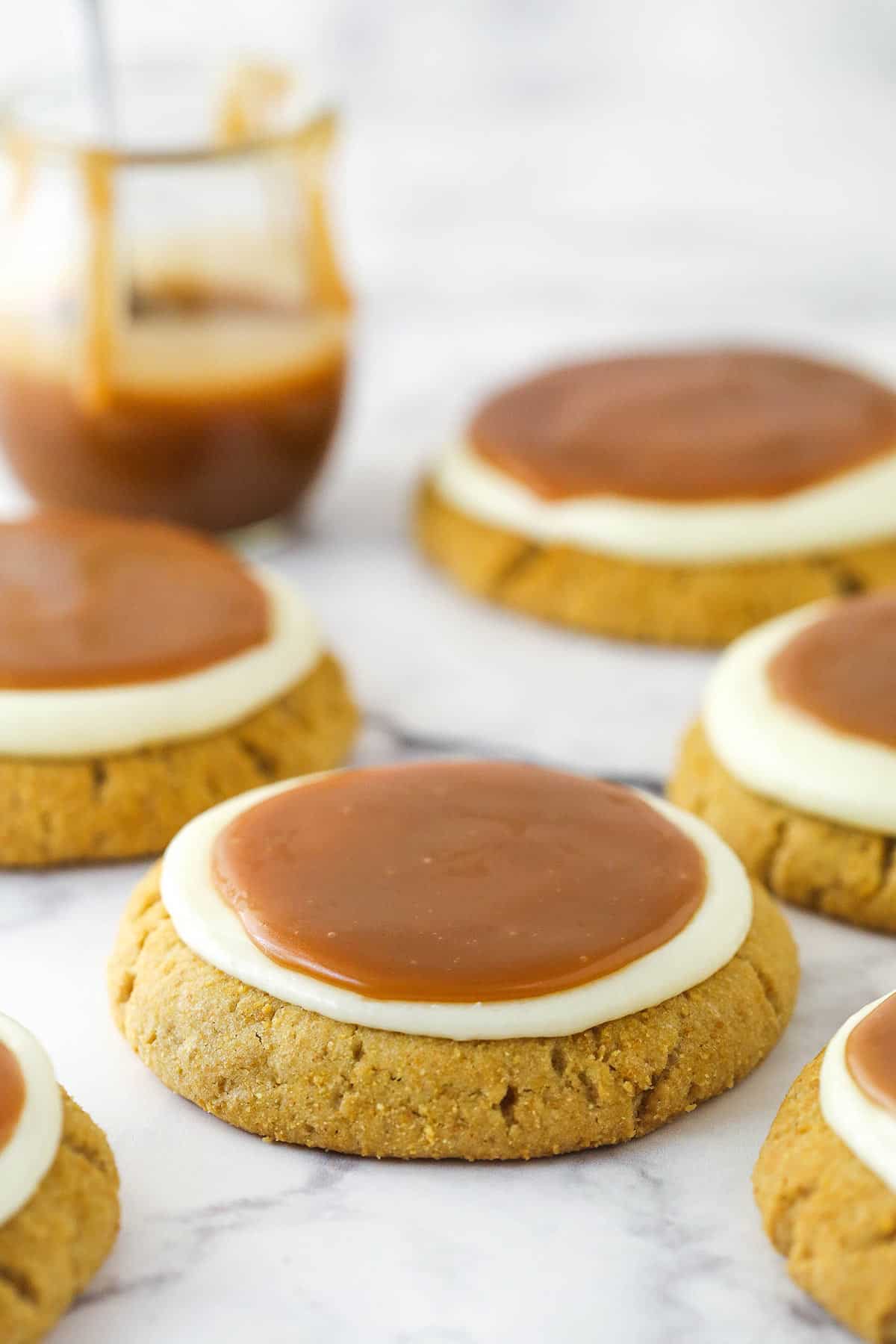 Salted caramel cheesecake cookies on a marble countertop.