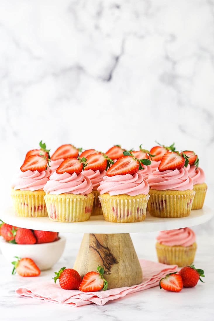 strawberry cupcakes on a marble stand and pink napkin