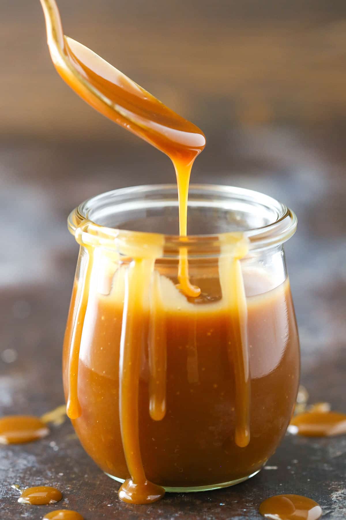 Drizzling caramel sauce into a jar.