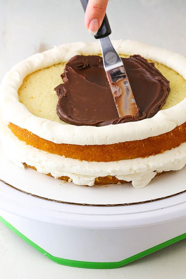 spreading frosting on layer cake with offset spatula