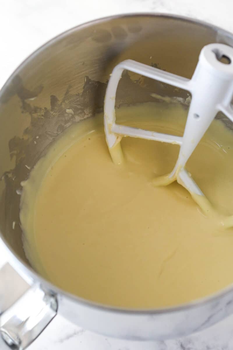 Mixing eggs into cheesecake batter.