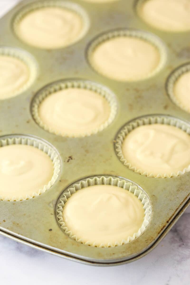 Filling cupcake liners with caramel cheesecake filling.
