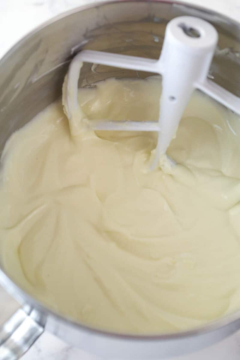 Mixing sour cream and extracts into mint cheesecake filling.