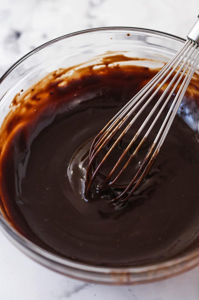 Whisking chocolate ganache in a mixing bowl.
