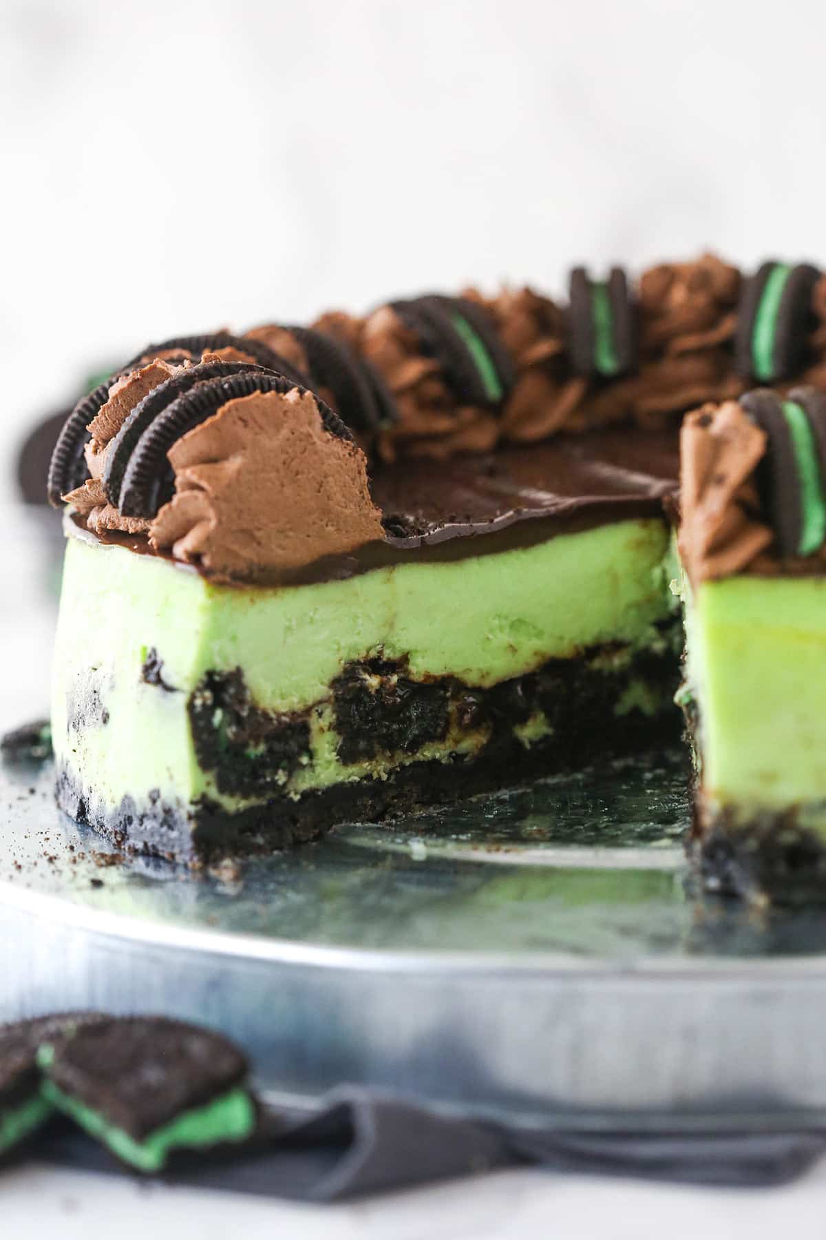 Mint Oreo cheesecake with a slice taken out of it.