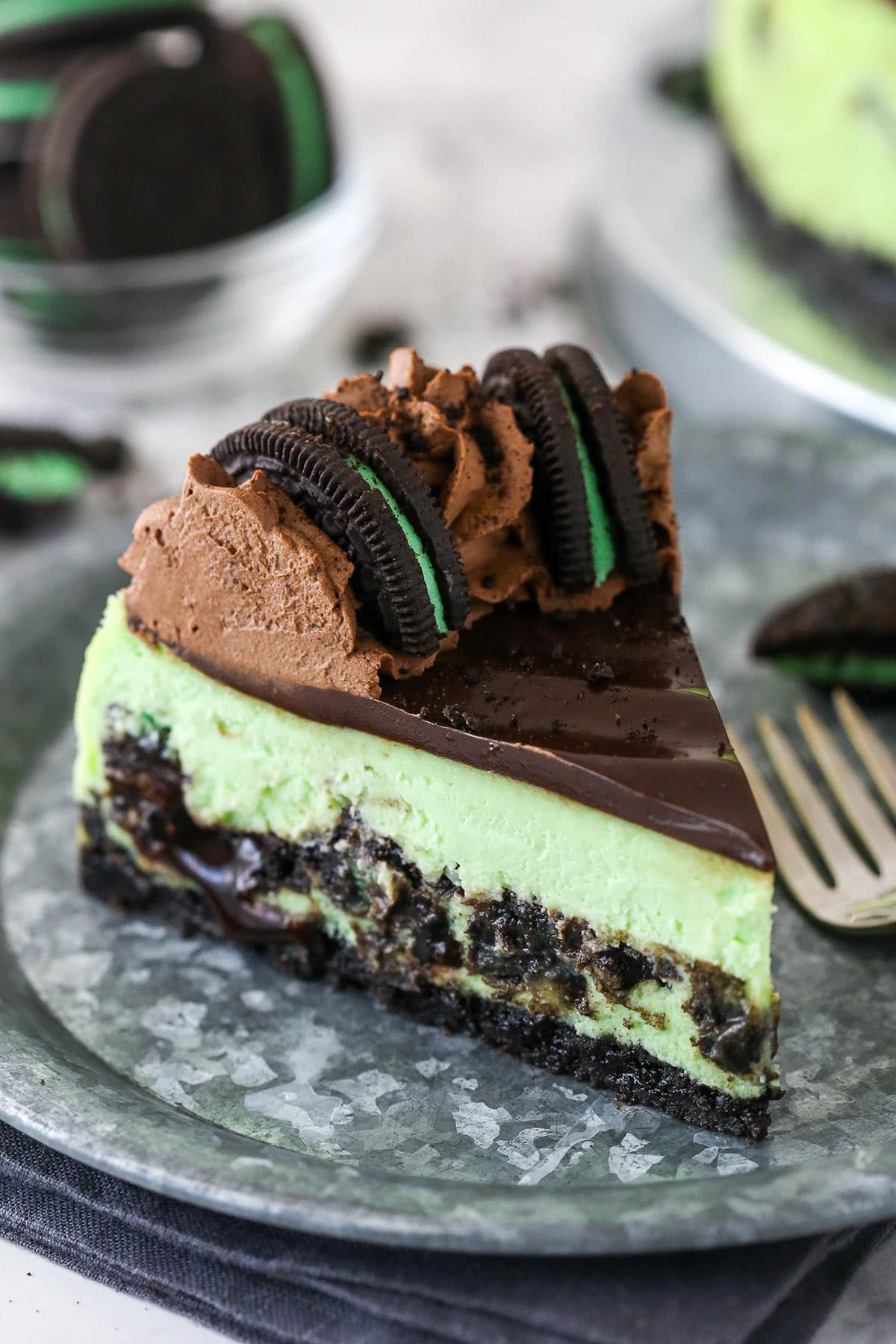 A slice of mint Oreo cheesecake on a plate.