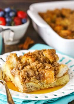 A slice of Overnight Cinnamon French Toast Casserole with syrup on a white plate