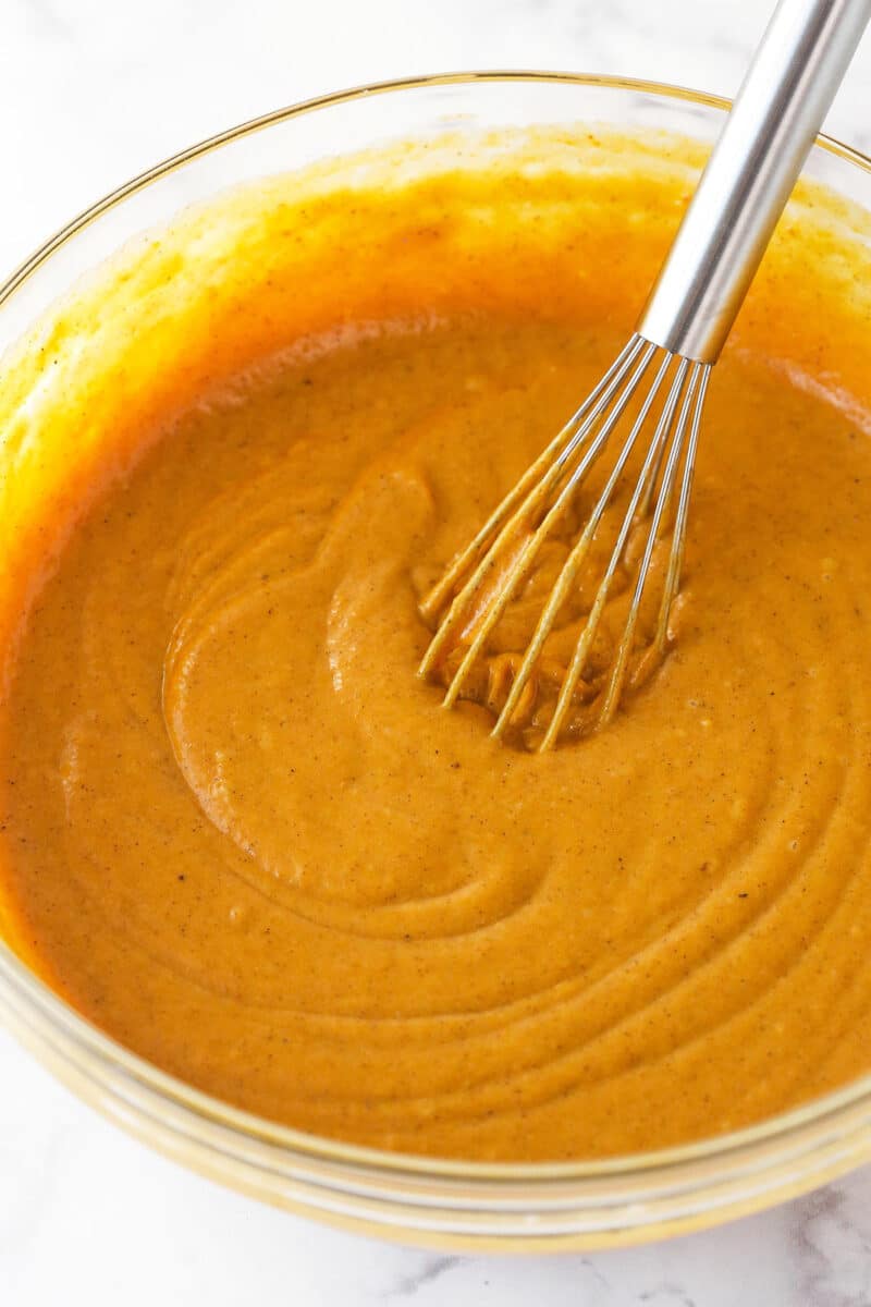 Combining wet and dry ingredients to make the batter for a pumpkin layer cake.