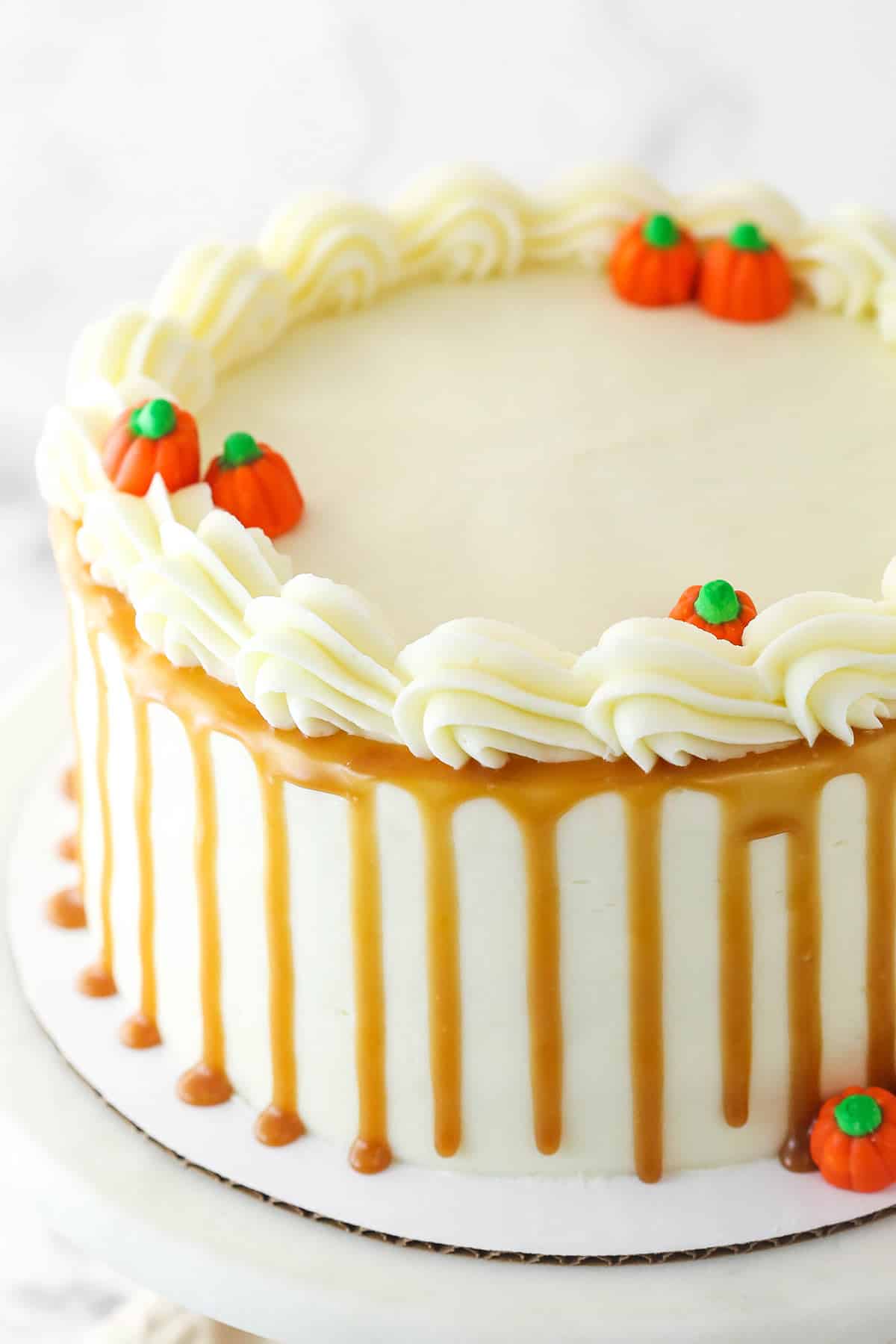 Pumpkin layer cake on a cardboard cake circle.