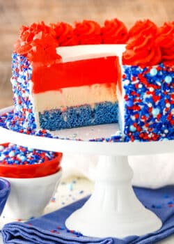 Red white and blue layer cake with sprinkles on the side.