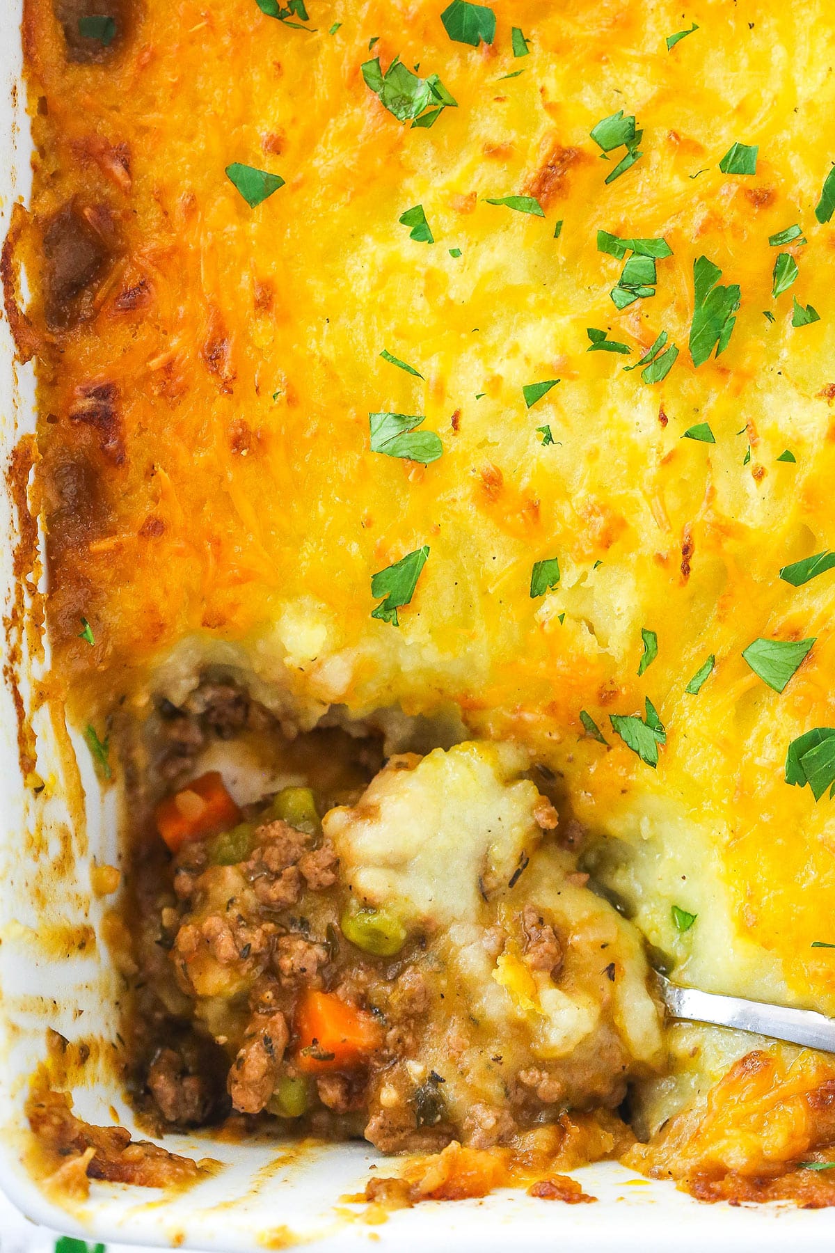 Shepherd's pie in a baking dish with a slice taken out of it.
